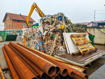 Stack of garbage on metal structure against sky