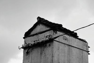 Low angle view of abandoned house against sky