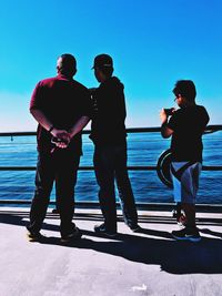 Silhouette men in sea against sky