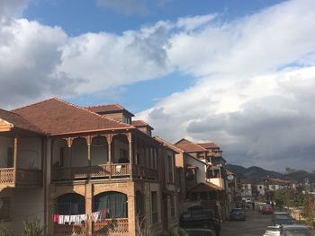 Buildings by road against sky in city