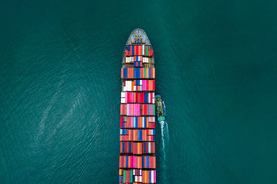 High angle view of shipping containers sailing export import international on the green sea