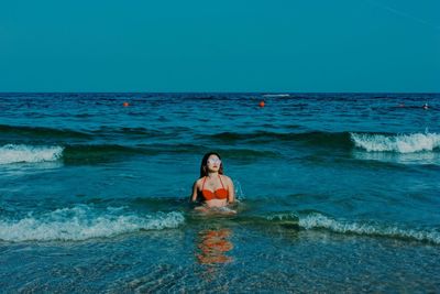 Man in sea against sky