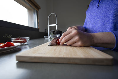 Low angle view of someone slicing a tomato