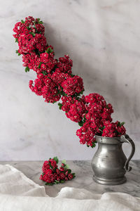 Close-up of red flower vase on table against wall