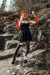 Full length of young woman standing against wall