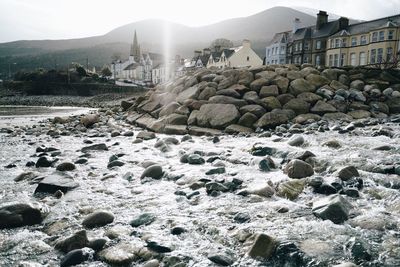 Rocks by sea against sky