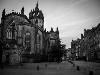 St giles cathedral by buildings in city against sky