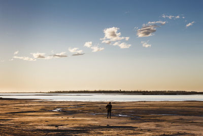 Silhouette person standing on beach against sky