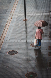 Rear view of woman walking on footpath