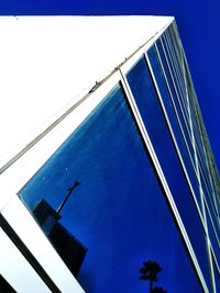 Low angle view of modern building against blue sky