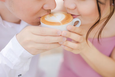 Midsection of couple drinking coffee