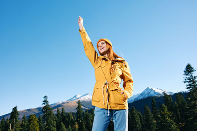 Portrait of woman standing against mountain