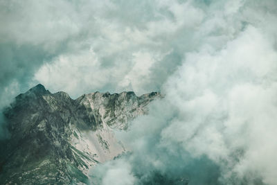 Low angle view of mountain against cloudy sky