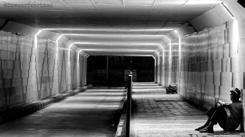 Poor man sitting under bridge subway