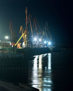 Illuminated bridge over river at night