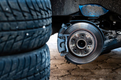 Winter tires next to the car, seasonal tire change concept, selective focus, focus on car, closeup