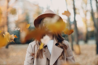 Portrait of woman standing against blurred background