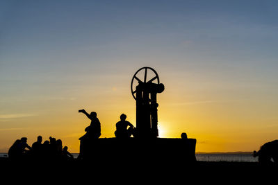 Silhouette people against sky during sunset