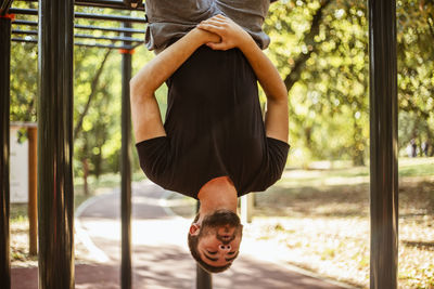 Sport man stretching at the park autumn, doing man do stretching exercises at autumn park. 