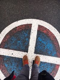 Low section of man standing on road marking