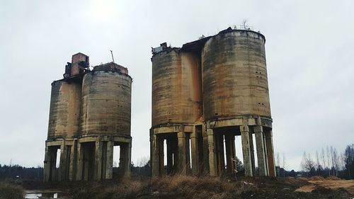 Low angle view of silos against sky