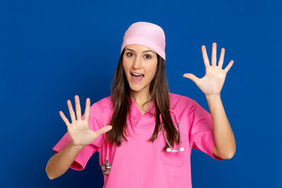 Portrait of smiling young woman standing against blue sky