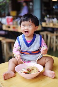 Cute boy sitting on table