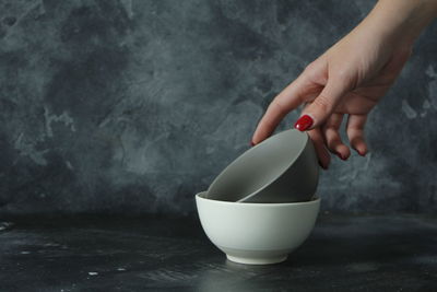 Woman hand taking grey empty bowl