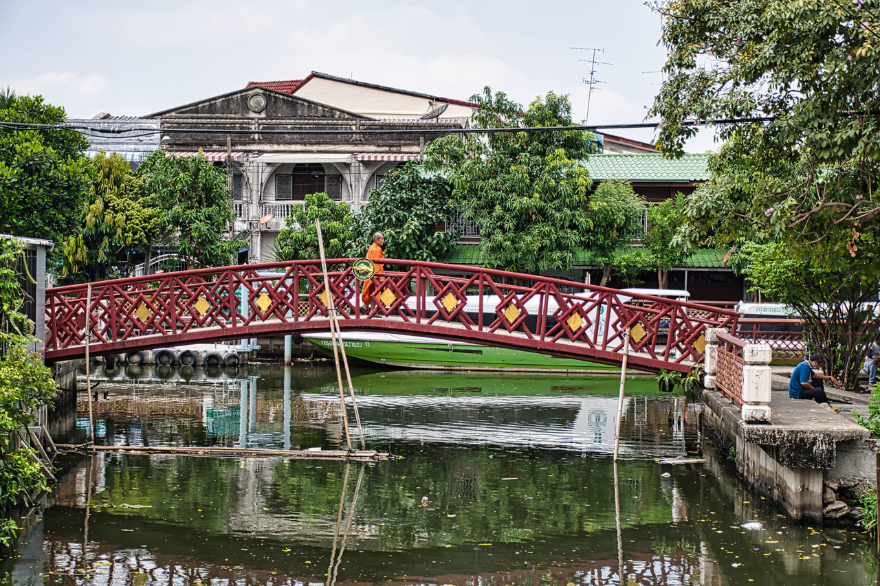 BRIDGE OVER RIVER AMIDST BUILDINGS