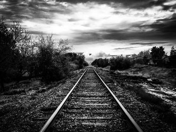 Railroad track against cloudy sky