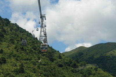 Low angle view of overhead cable car against sky