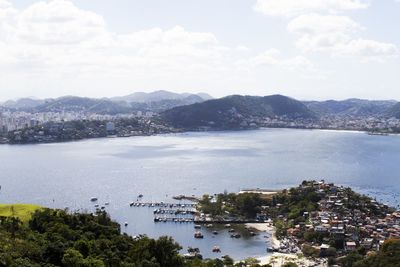 High angle view of town by sea against sky