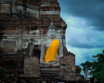 Low angle view of statues on building against sky