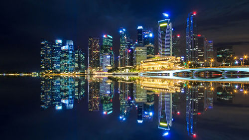 Reflection of modern illuminated buildings in river at night