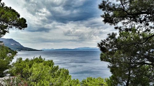 Scenic view of calm sea against cloudy sky