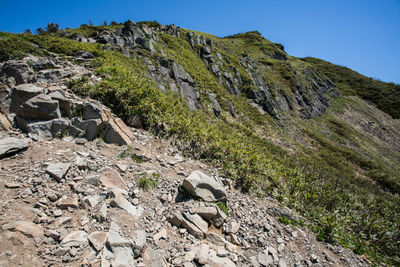 Low angle view of rocks on mountain against sky