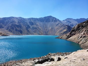 Scenic view of lake and mountains against clear blue sky