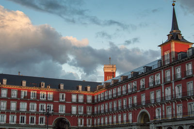 Buildings in city against cloudy sky