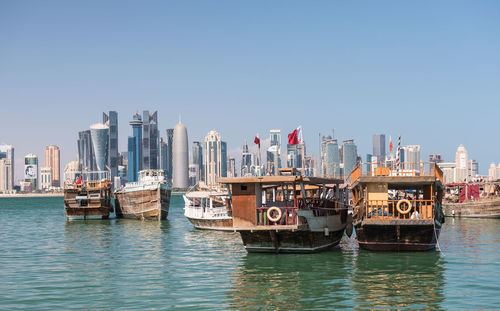 Boats moored in sea against clear sky