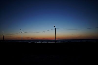 Scenic view of beach against clear sky during sunset