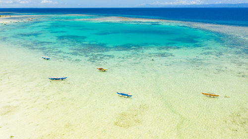 Atoll with turquoise water and boats.