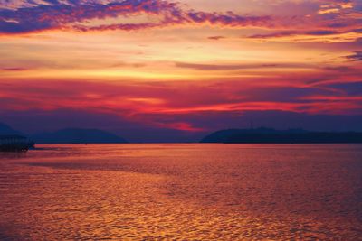 Scenic view of sea against dramatic sky during sunset