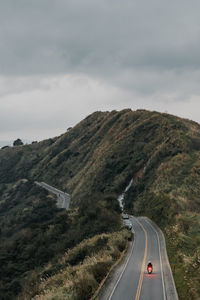 Country road by mountain against sky