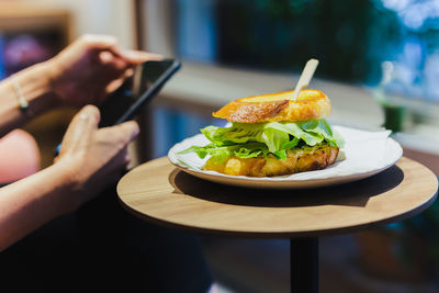 Cropped hand of woman having food