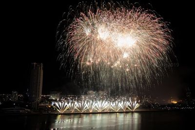 Firework display over river at night