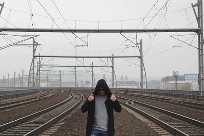 Man standing on railway tracks against clear sky