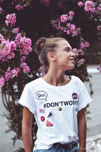 Young woman standing against tree