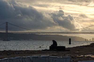 View of suspension bridge against cloudy sky