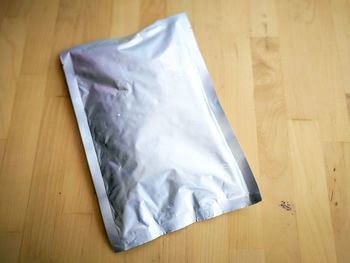 High angle view of plastic foil bag on hardwood floor