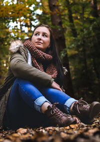 Portrait of young woman sitting in forest